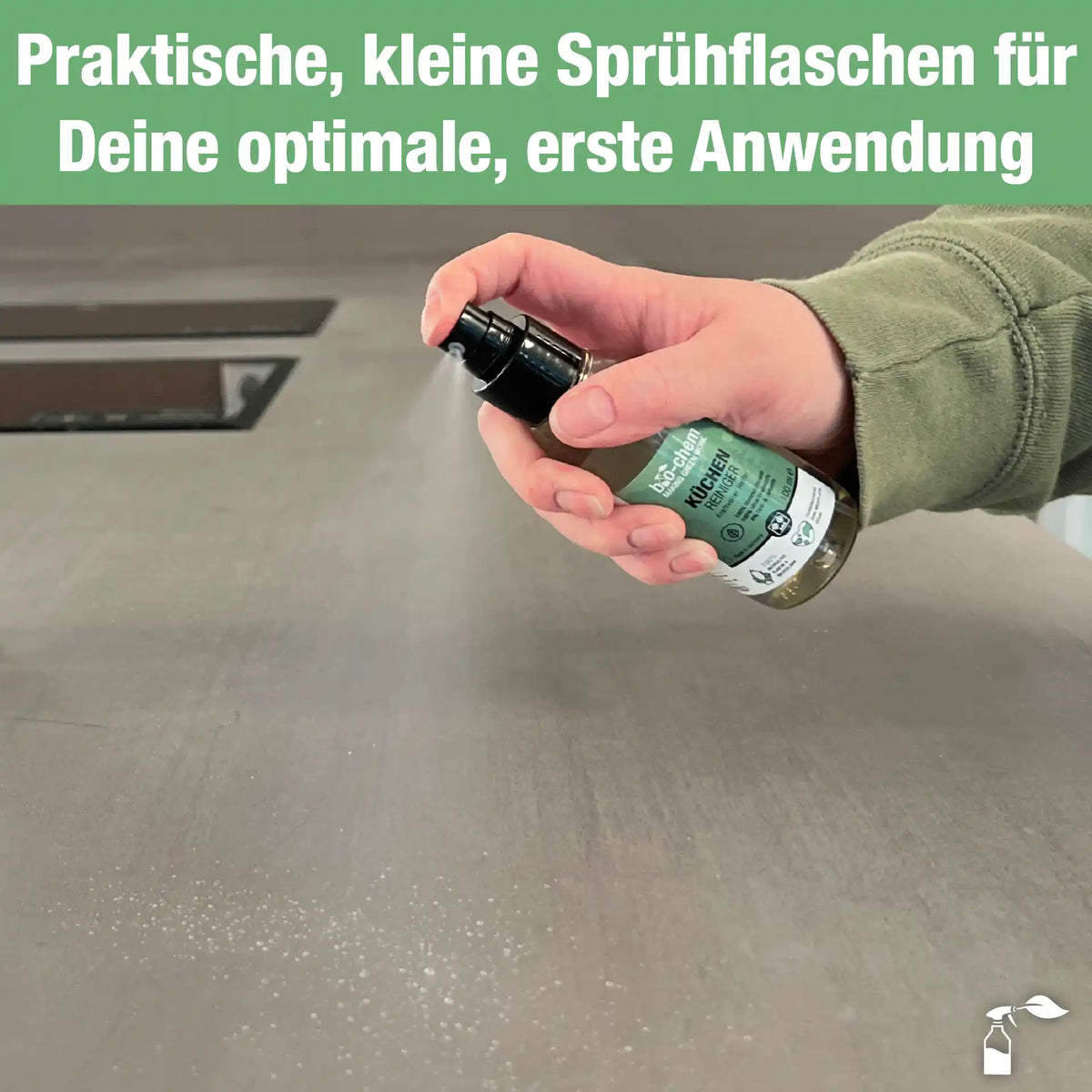 Hand sprüht Küchenreiniger auf Arbeitsfläche, feiner Sprühnebel sichtbar, für gezielte Anwendung
